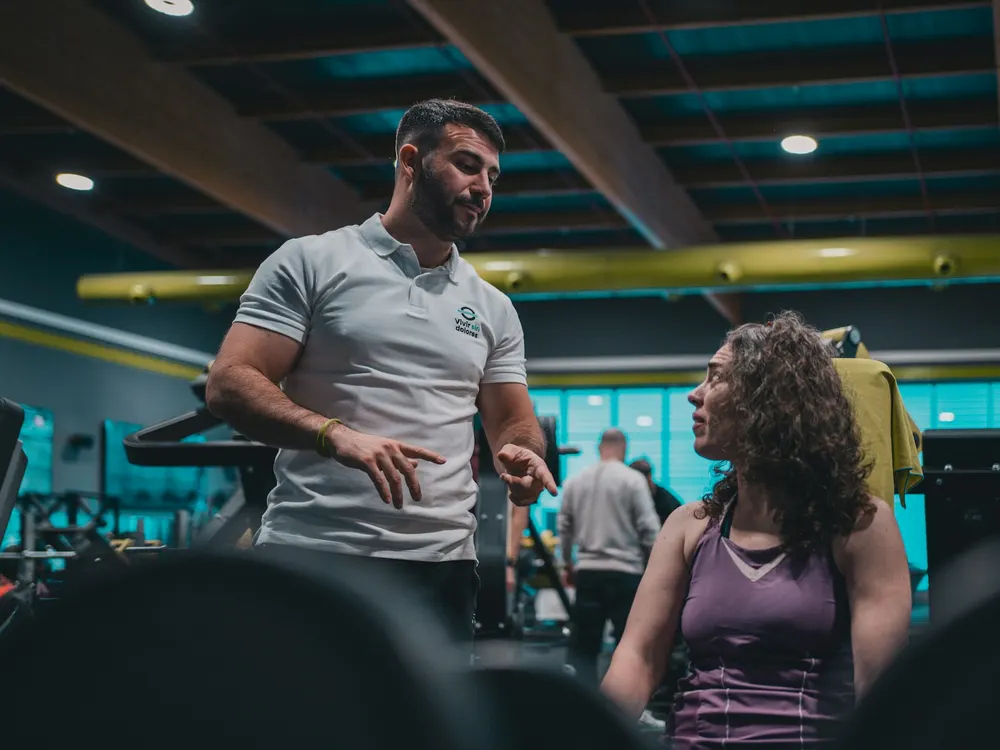 Personal acompanhando treino na academia